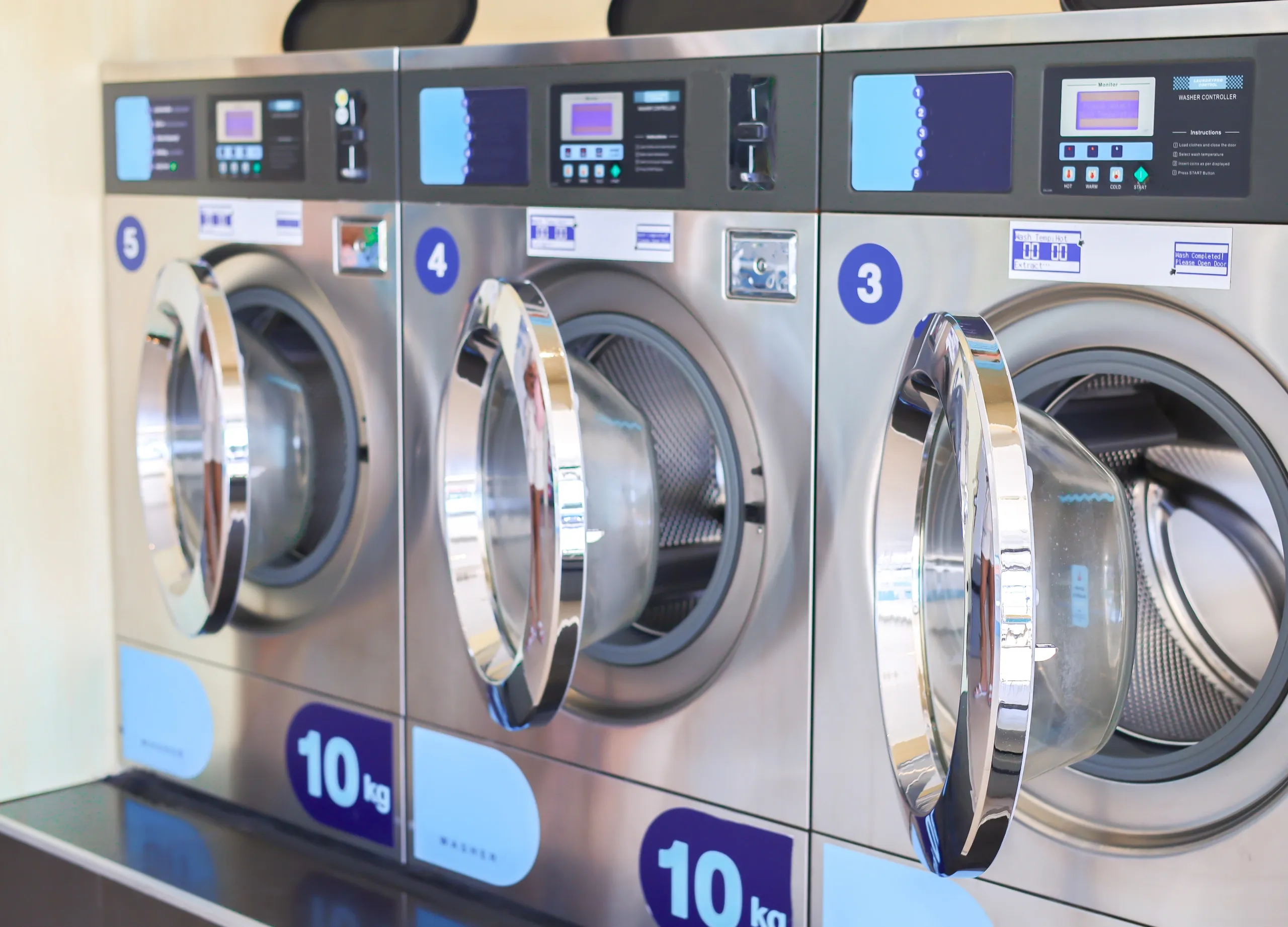 Three industrial washing machines in a row.